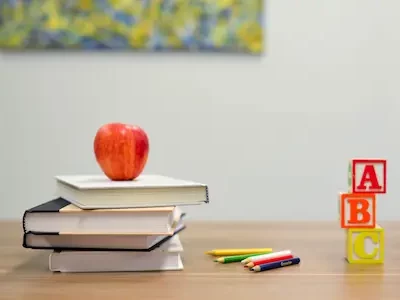 libros y manzana sobre una mesa de estudio